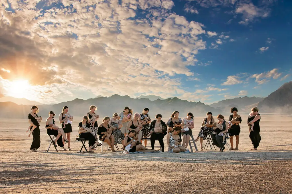 A group of people sitting on chairs in the sand.