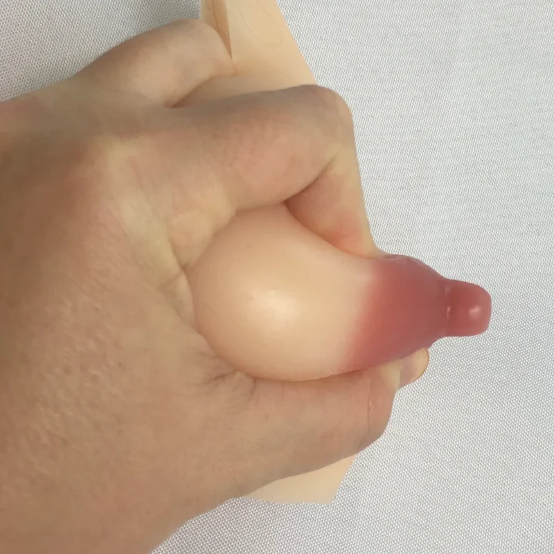 A person's hand demonstrating how to express milk or colostrum from a breast