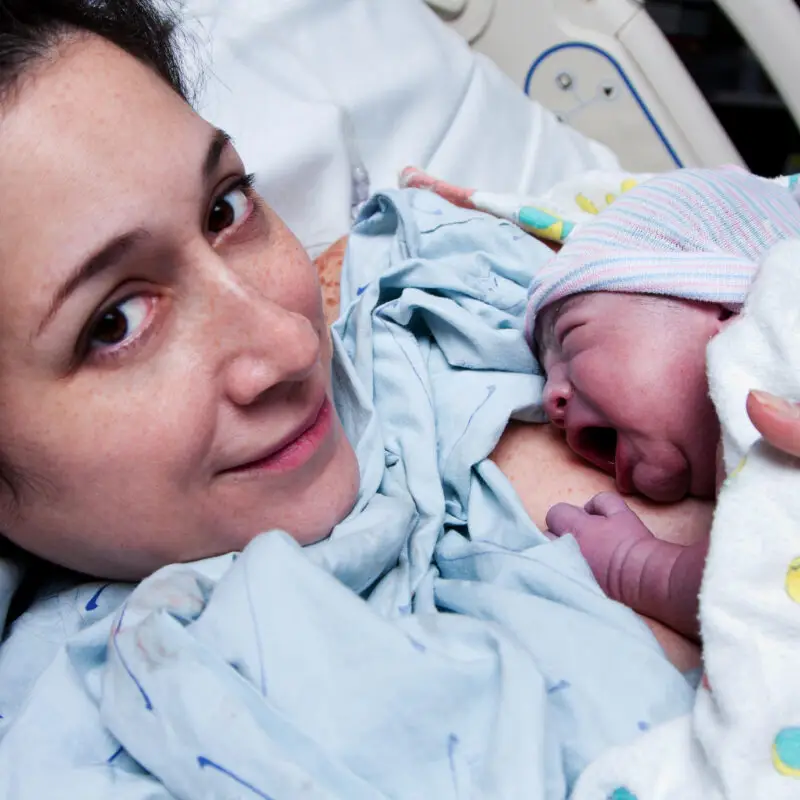 A woman holding a baby in her arms.