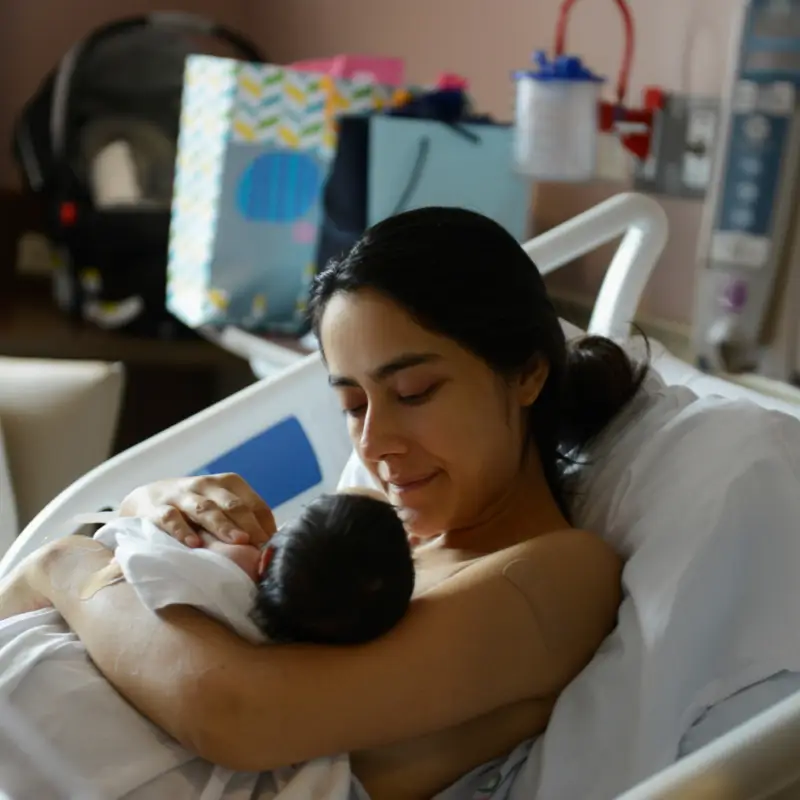 A woman holding a baby in her arms.