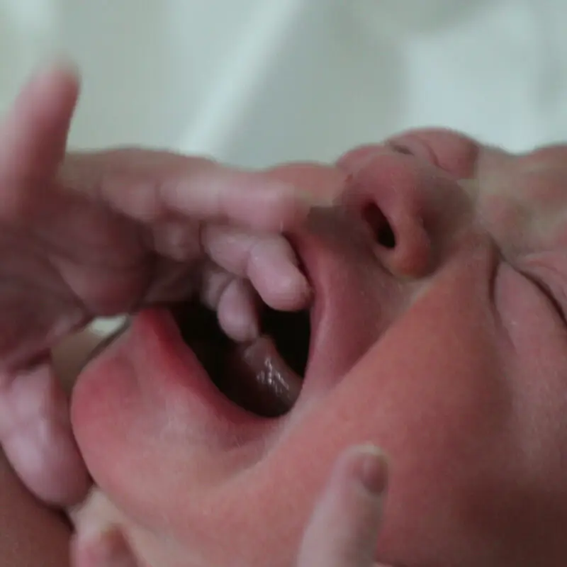 A baby is being fed by someone else.