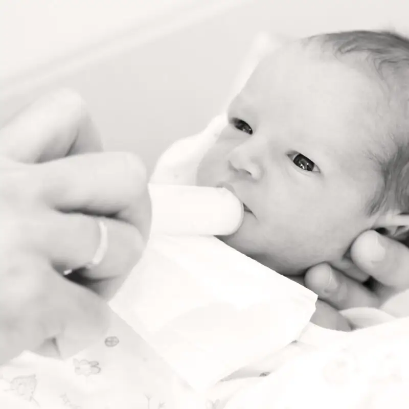 A baby is being fed by someone else.