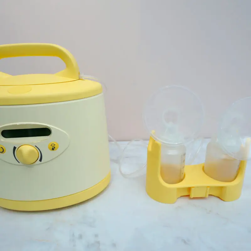 A yellow and white electric cooker with two cups.