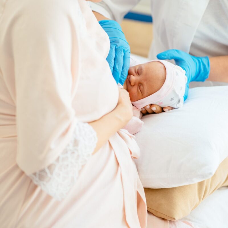 Breastfeeding mother getting help with breastfeeding her baby