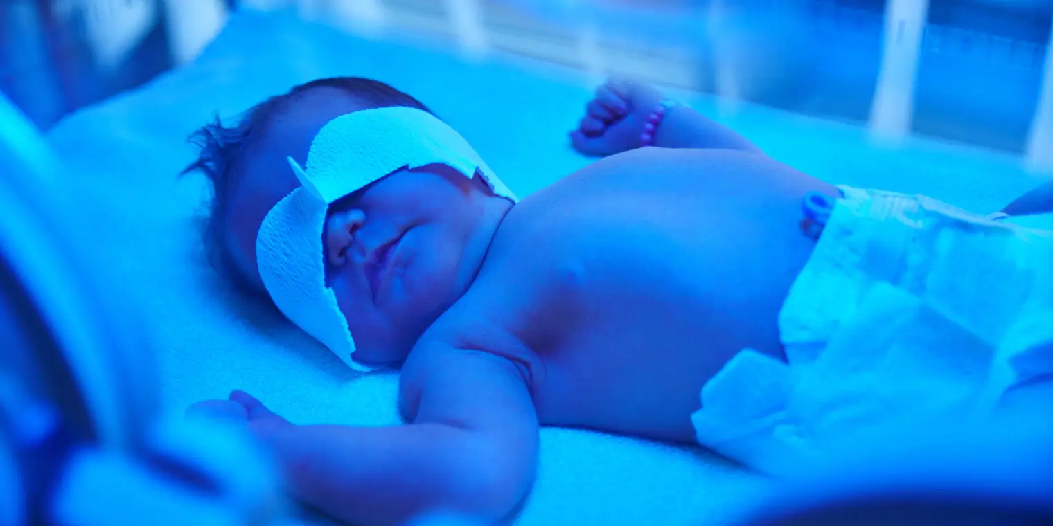 A baby is laying in the hospital bed.
