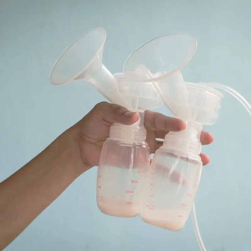 A person holding an empty bottle of breast milk.