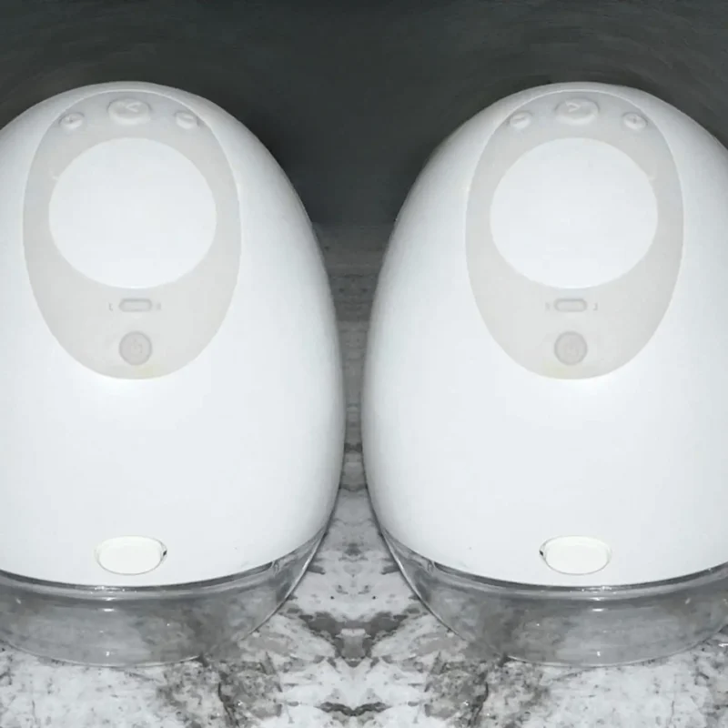 Two white speakers sitting on top of a marble floor.