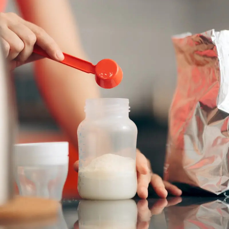 A person is putting food in a jar