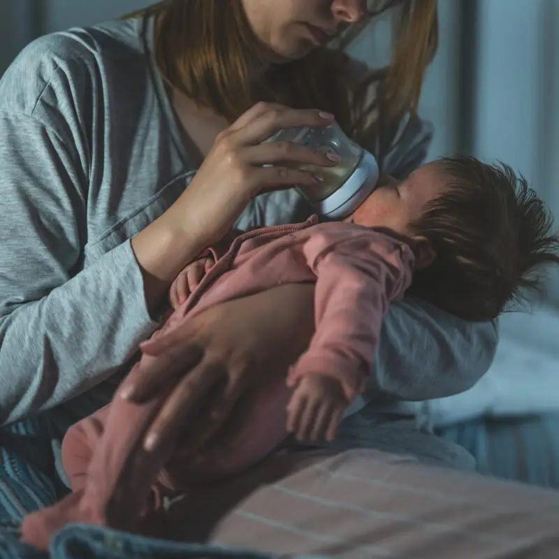 A woman holding a baby in her arms.