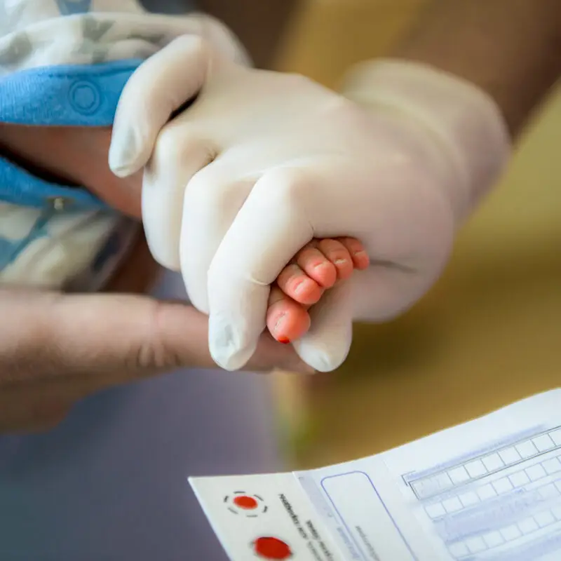 A person wearing white gloves holding hands with another person.