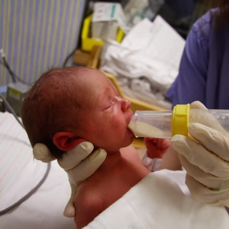 A baby being held up by a doctor