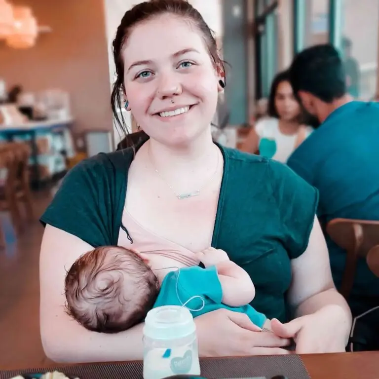 A woman holding her baby in a restaurant.