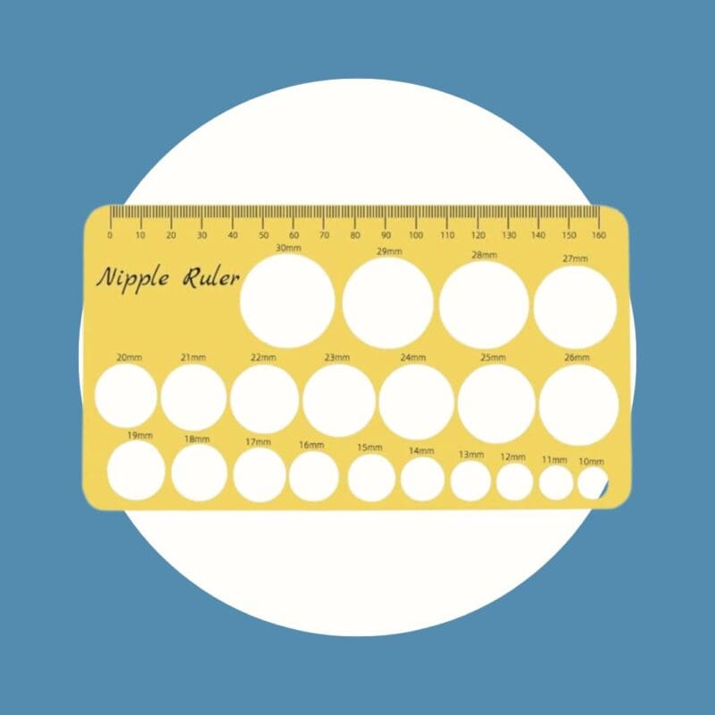 yellow nipple ruler with white holes on a blue and white background